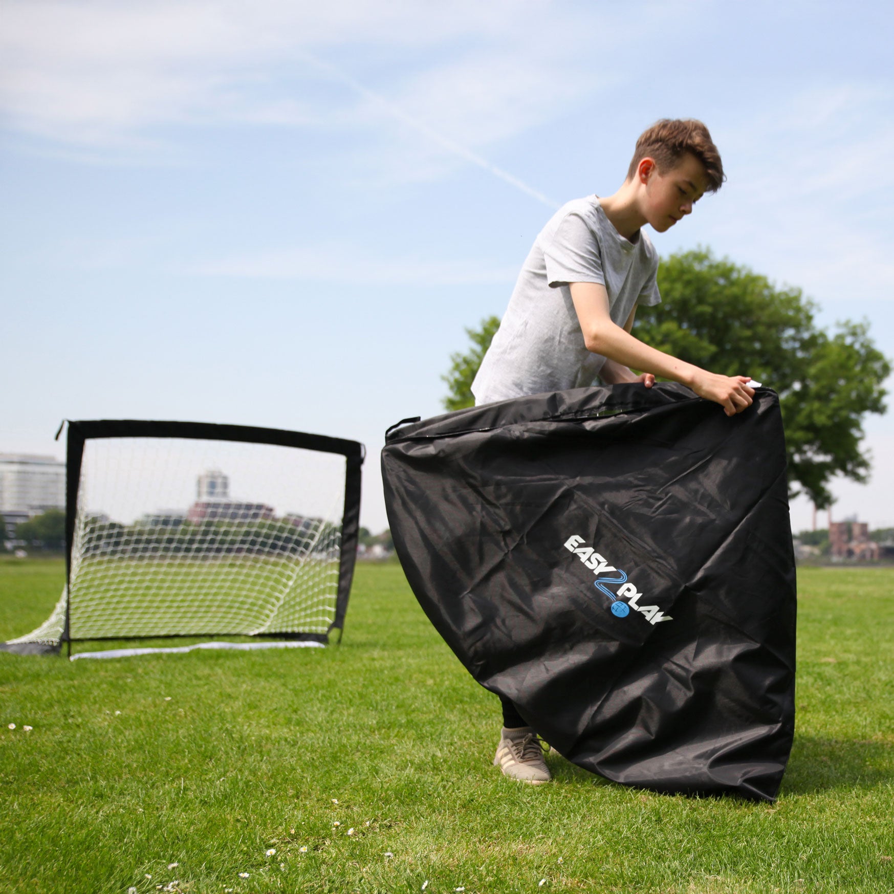 Ein Junge holt das Easy2Play Fussballtor Set aus der Tragetasche, um es aufzubauen